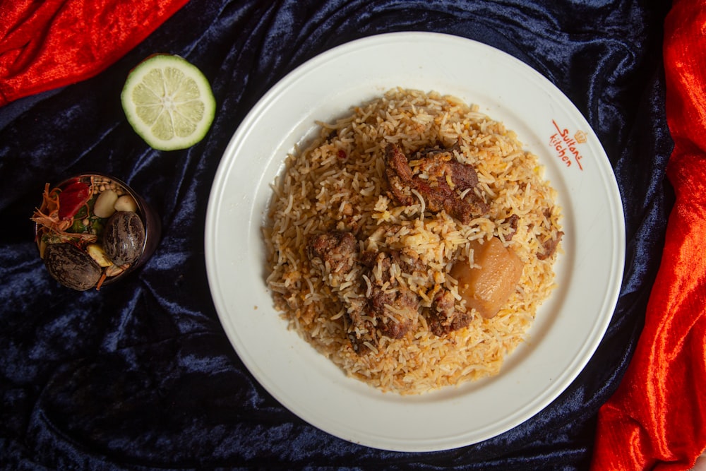 a white plate topped with rice and meat