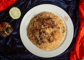 a white plate topped with rice and meat