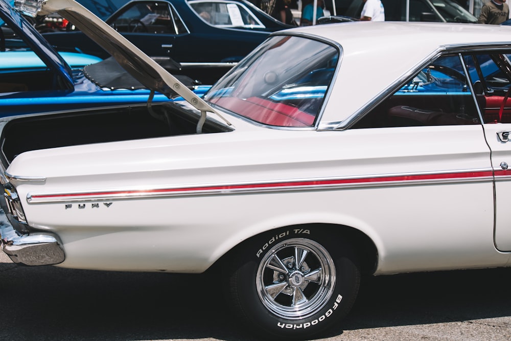 a white car parked in a parking lot next to other cars