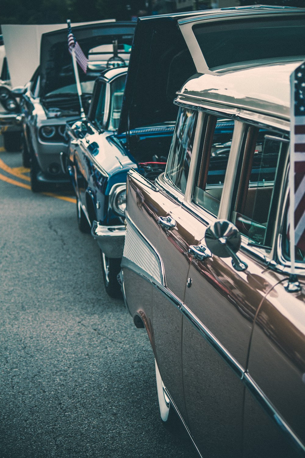 a row of old cars parked on the side of the road