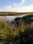 A serene landscape with a tranquil river reflecting the sky.
