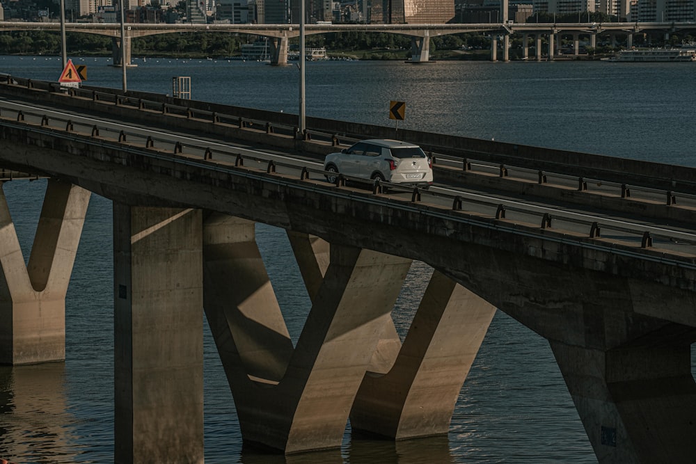a car driving on a bridge over a body of water