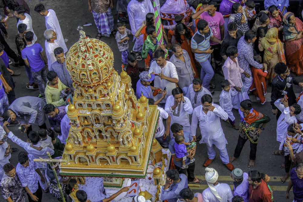 a group of people standing around a golden statue