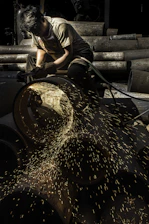 Close-up of a worker using heavy-duty industrial tools in a workshop