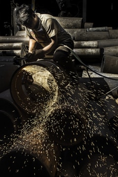 Close-up of a skilled worker polishing a stainless steel pot in the factory.