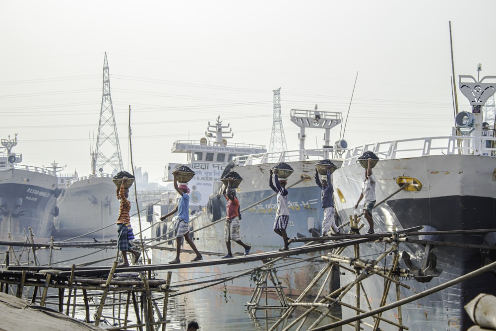 a group of people walking across a wooden dock