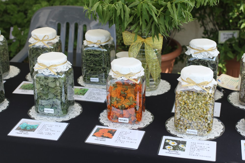 a table topped with jars filled with different types of herbs