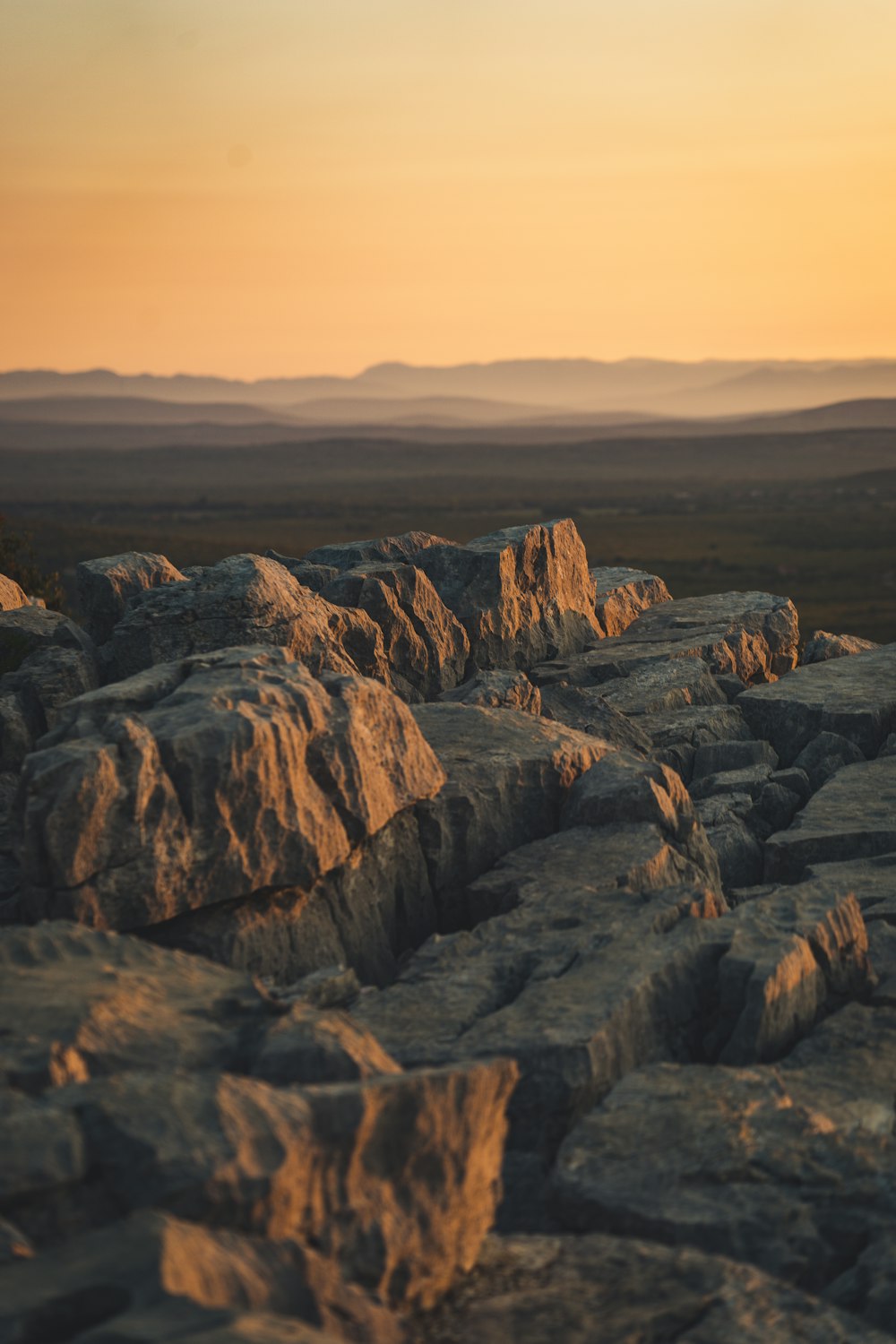 the sun is setting over the rocky terrain