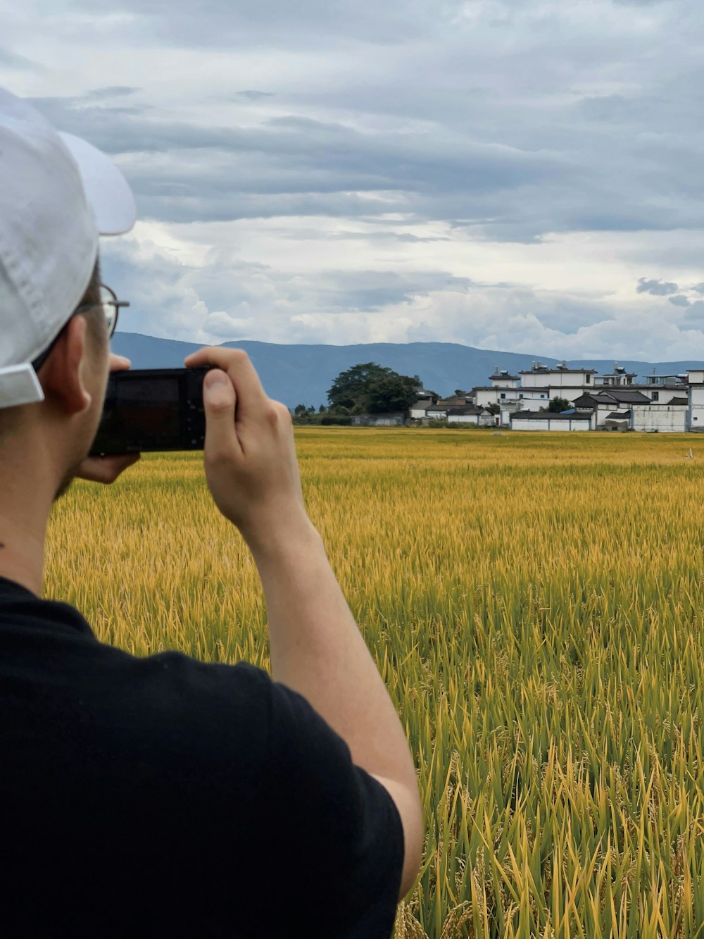 a man taking a picture of a field with a cell phone