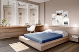 Modern platform bed with sleek wooden frame and vibrant blue bedding in a minimalist room.