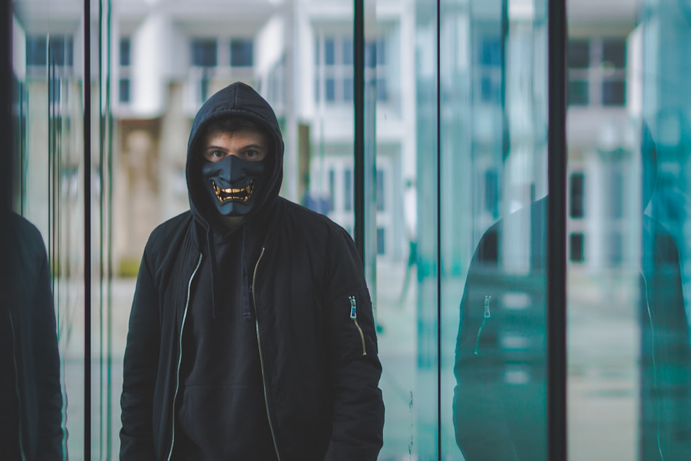 a man wearing a black mask and a black jacket