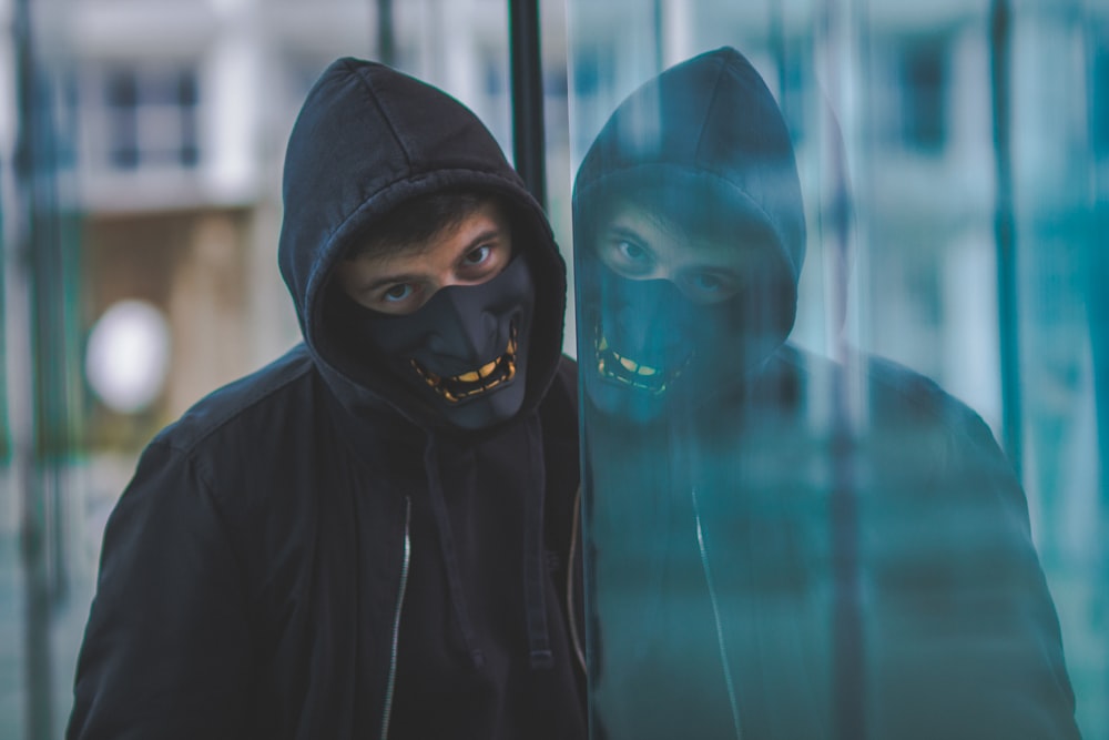 a man in a black hoodie and a man in a black mask