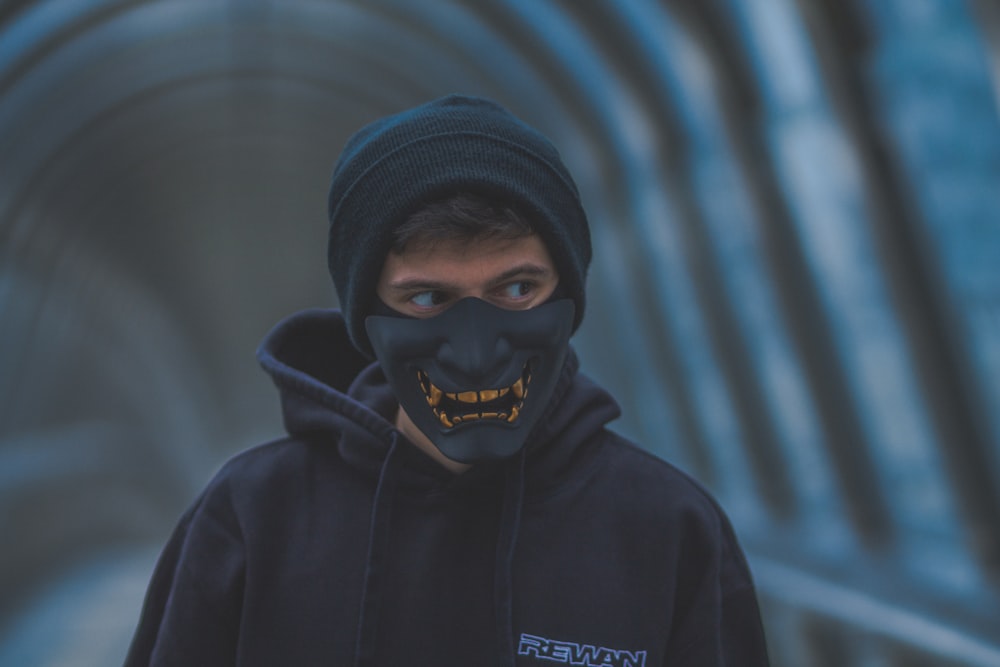 Ein Mann mit schwarzer Maske und schwarzem Kapuzenpullover