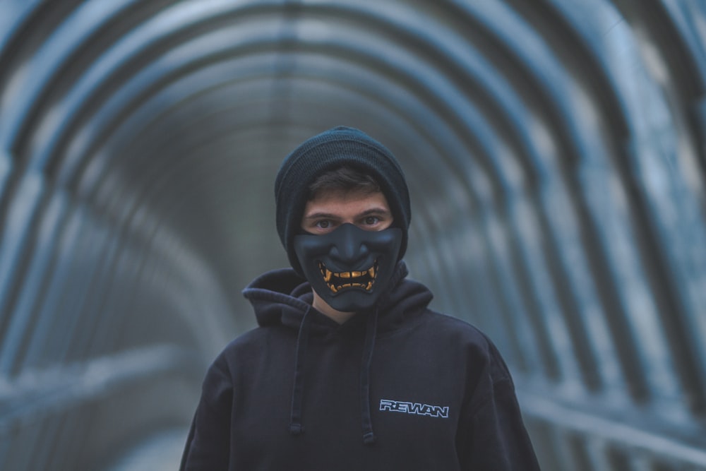 a man wearing a black mask and a black hoodie