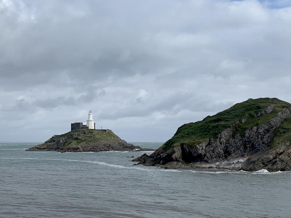 a lighthouse on a small island in the middle of the ocean