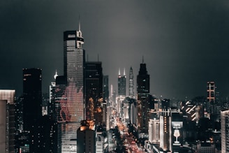A bustling city skyline at night with illuminated skyscrapers.