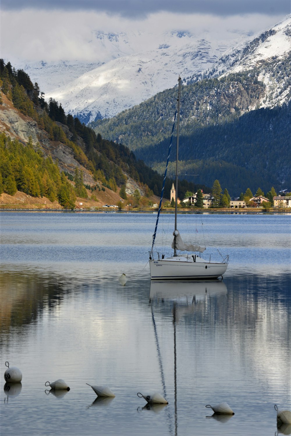 a sailboat on a lake with mountains in the background