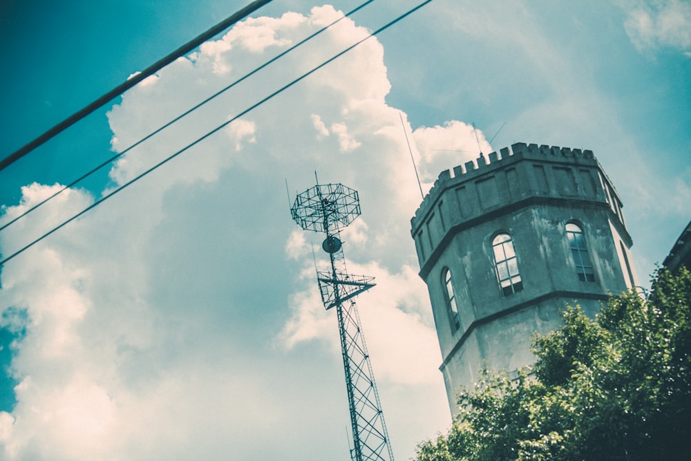 a tall tower with a weather vane next to it