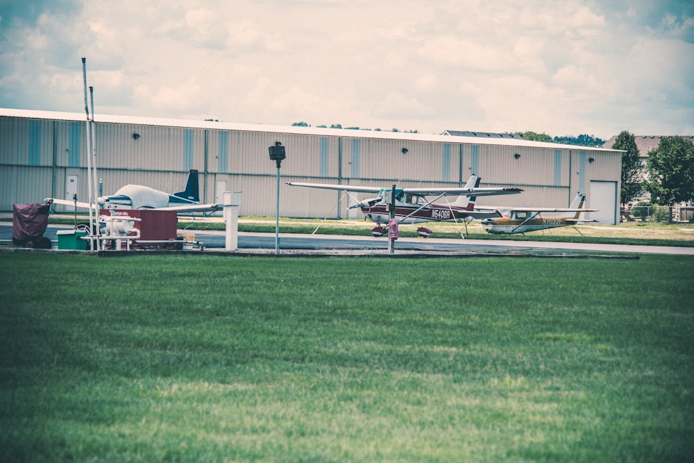 um pequeno avião estacionado em frente a um hangar