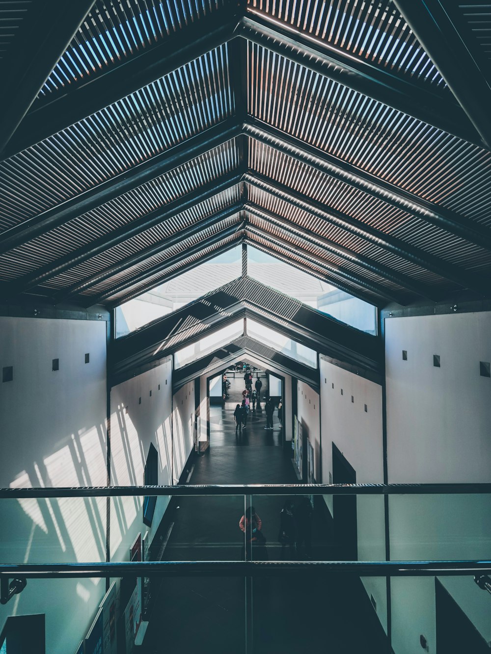 a long hallway with a wooden ceiling and metal railings