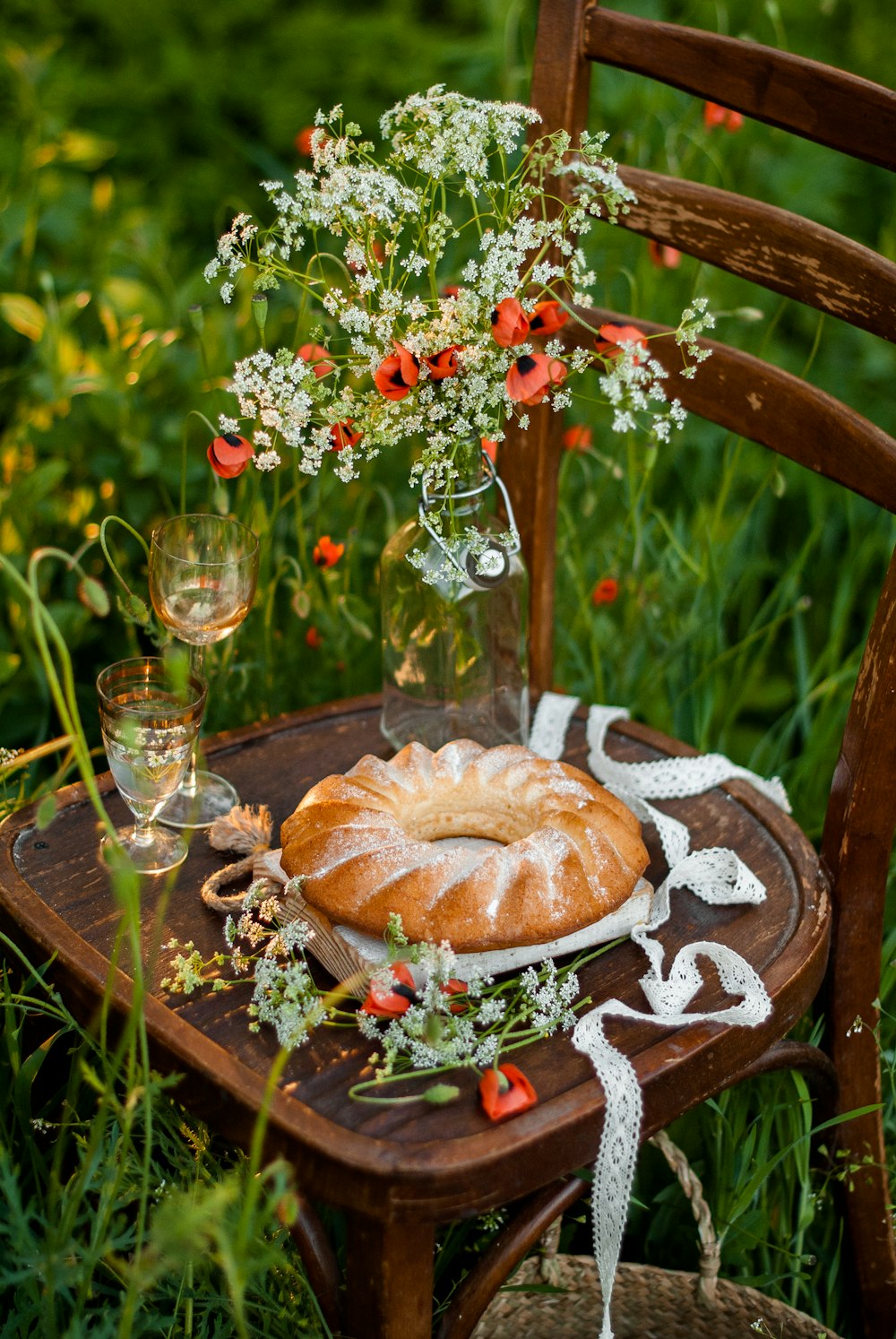 a table topped with a bundt cake next to a glass of wine