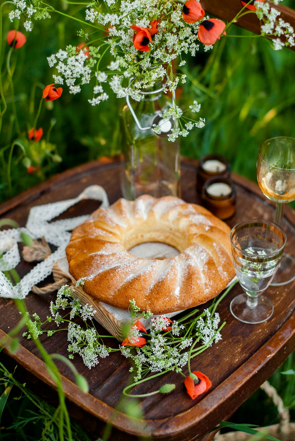 a table topped with a bundt cake next to a glass of wine