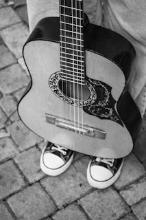 a person holding a guitar on the ground