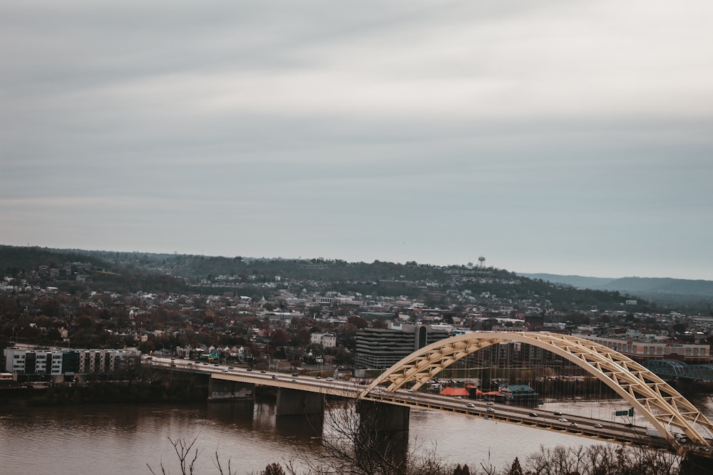 a bridge over a river with a city in the background