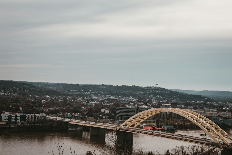A bridge over a river with a city in the background