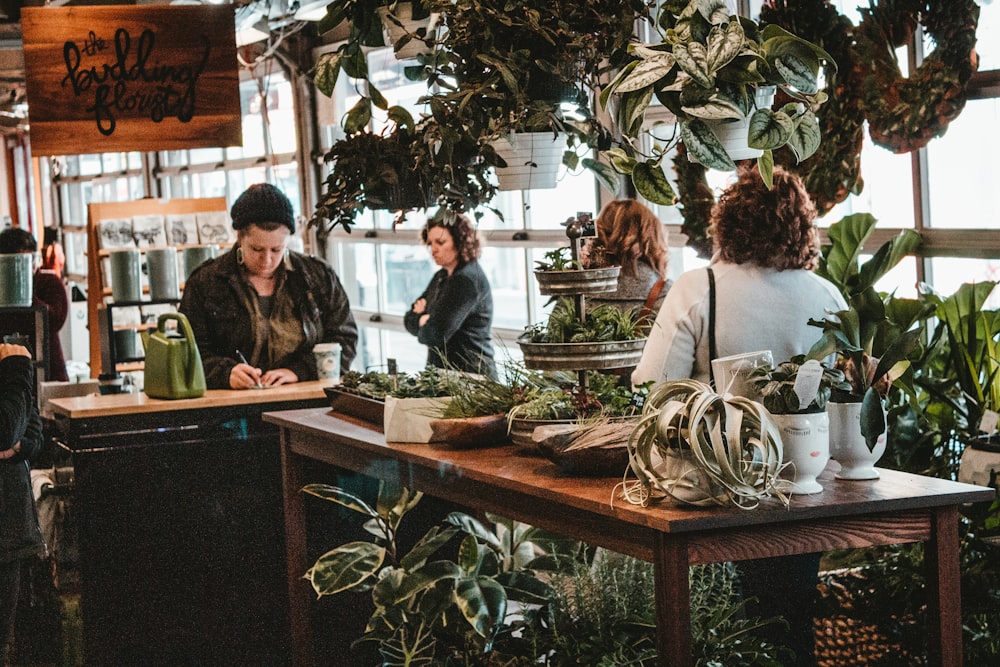 a group of people standing around a wooden table