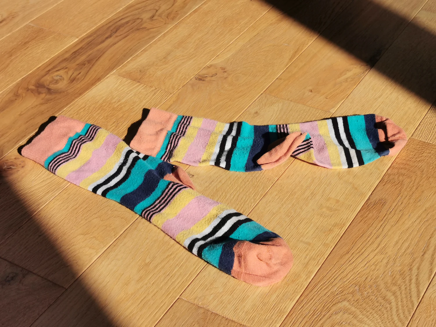 Full Spectrum tube sock in the Terracotta Deck colourway on a wooden floor