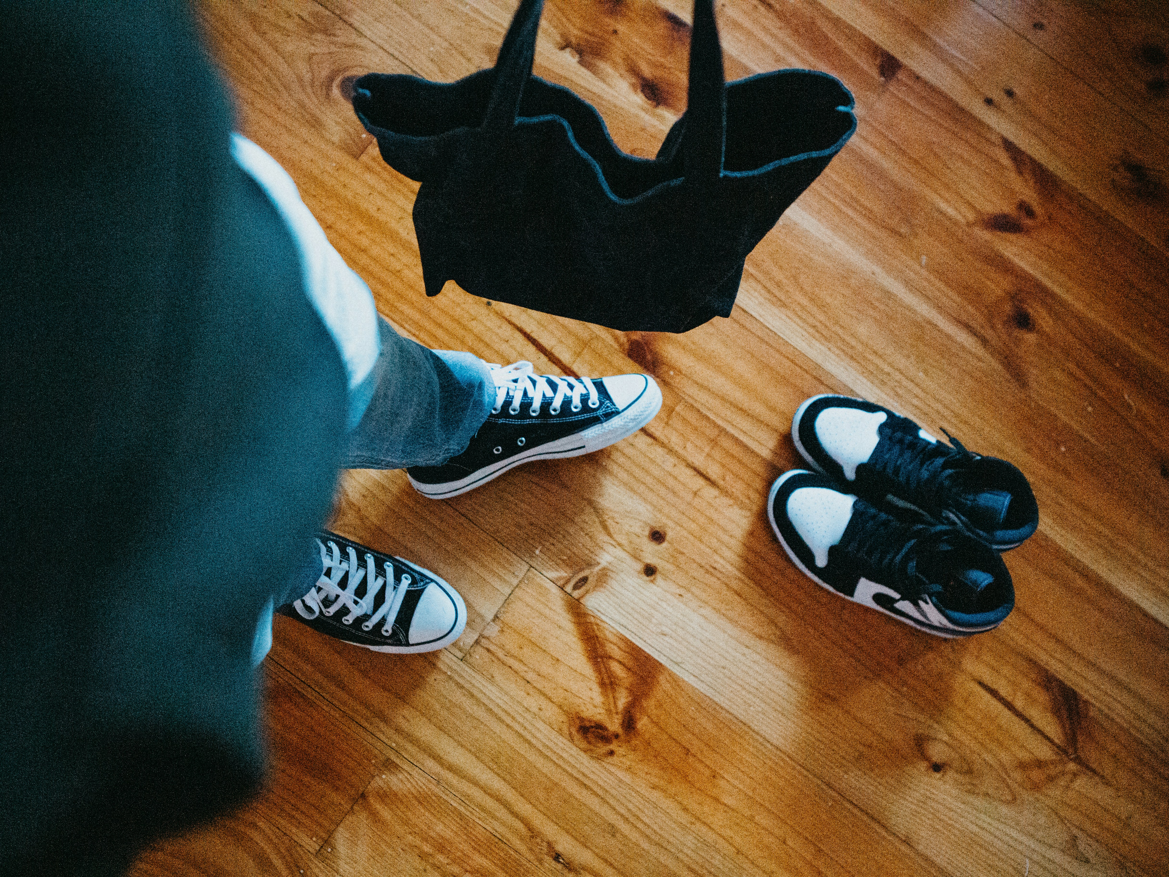a pair of shoes and a bag on a wooden floor