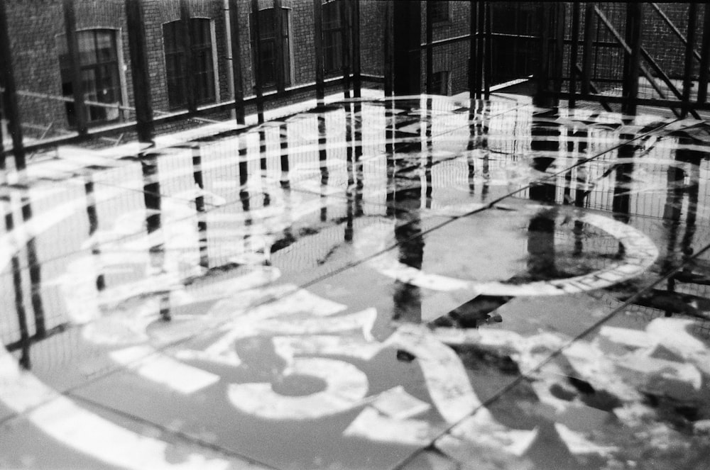 a black and white photo of a reflection of a building