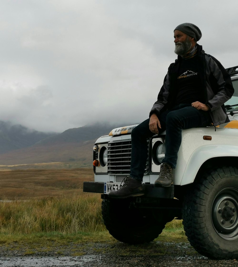 a man sitting on top of a white truck