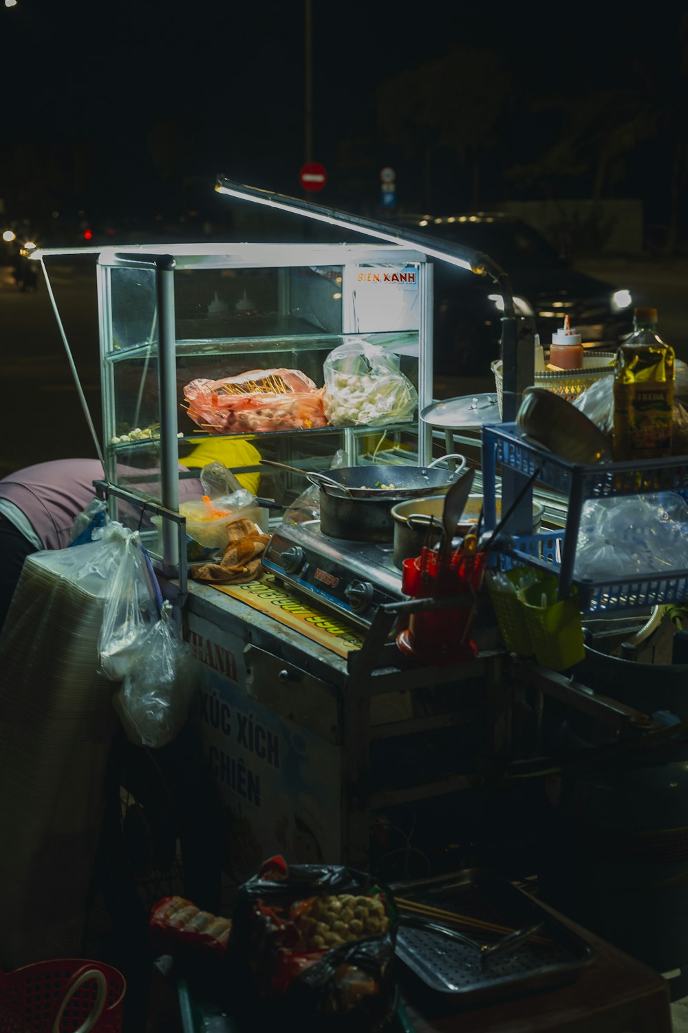 a food cart sitting on the side of a road at night