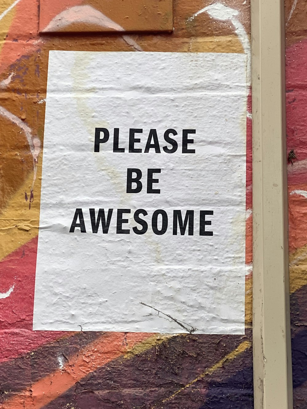 a sign on a wall that says please be awesome