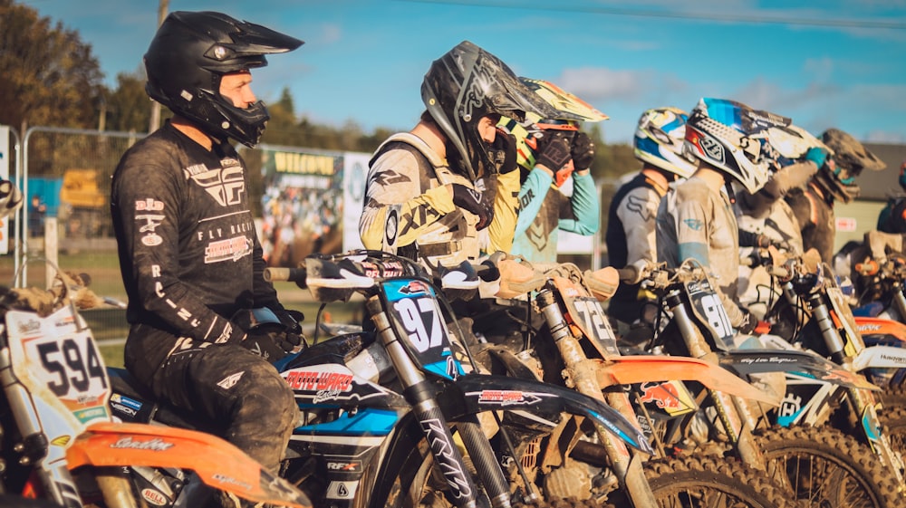 a group of dirt bike riders sitting on their bikes