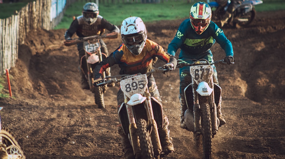 a group of people riding dirt bikes on a dirt track