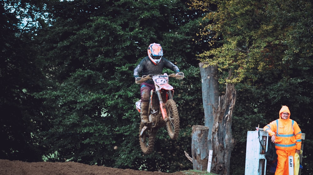 a man riding a dirt bike over a jump
