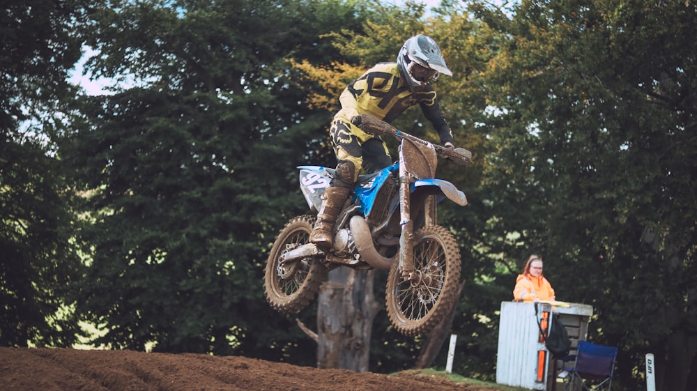 a man riding a dirt bike on top of a wooden stump