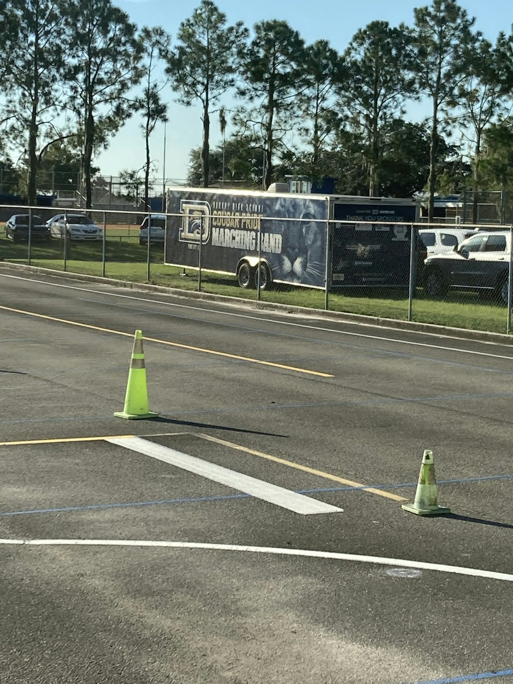 a parking lot with a fence and a truck in the background
