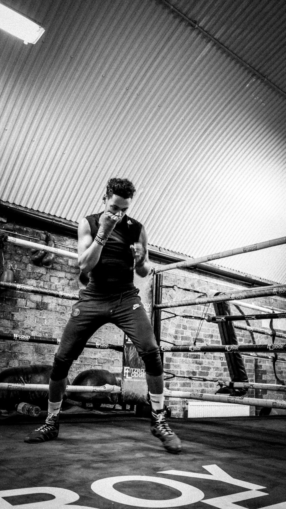 a man standing in a boxing ring talking on a cell phone