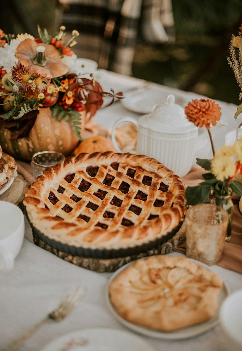 a table topped with pies and plates of food