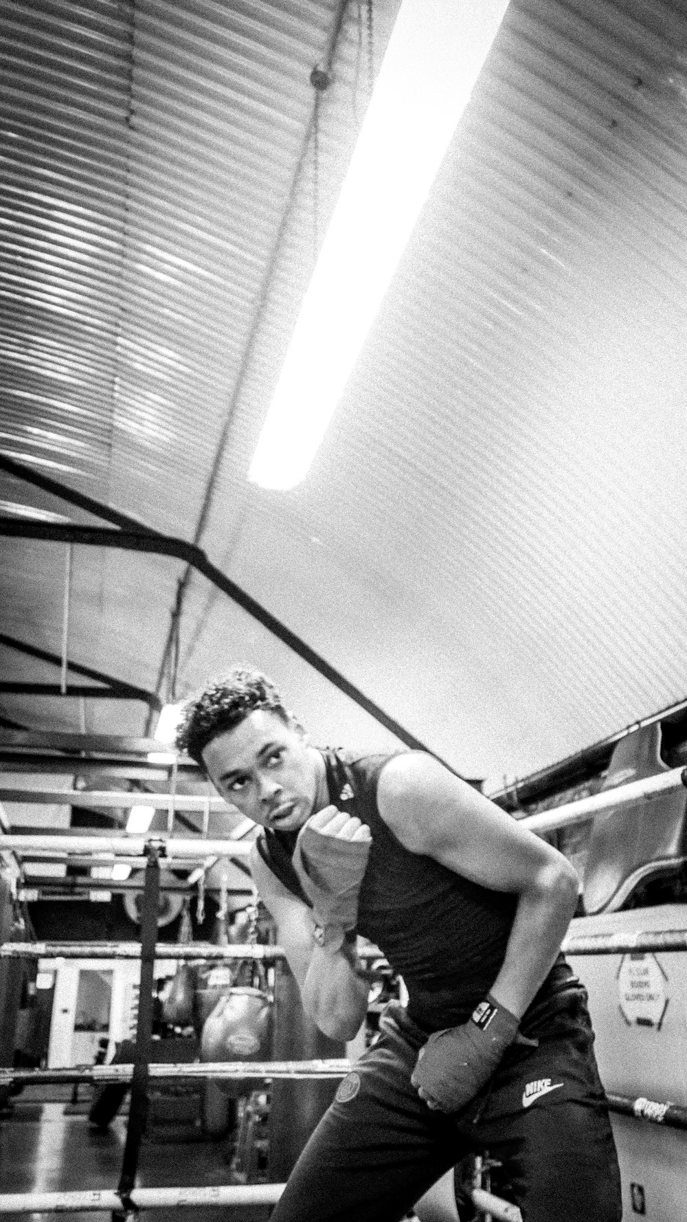 a man standing in a boxing ring holding a punching glove