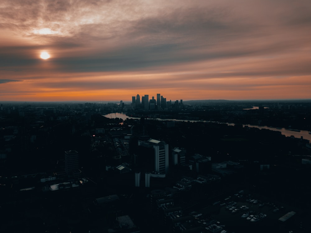 the sun is setting over a city with tall buildings