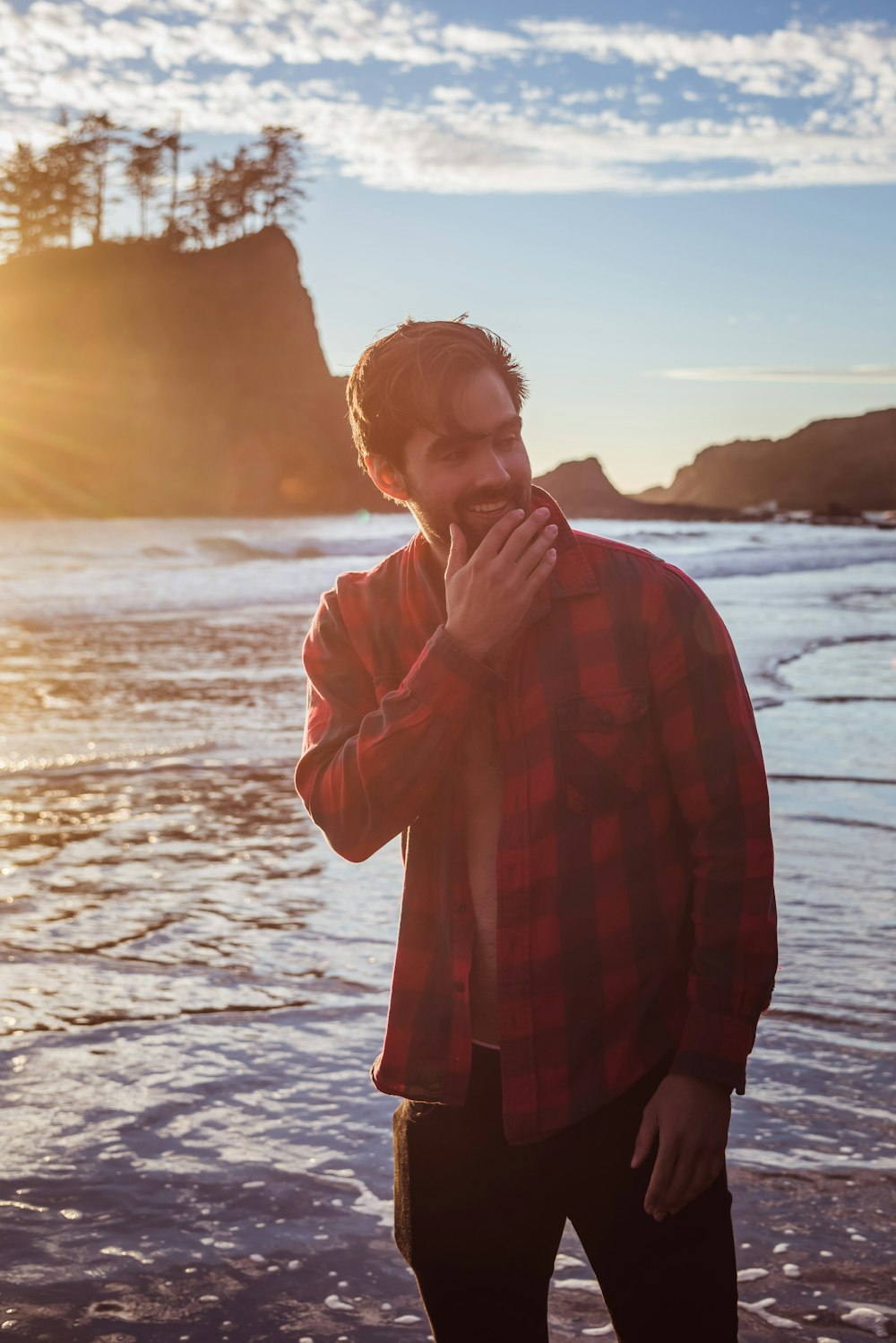 a man standing on a beach next to the ocean