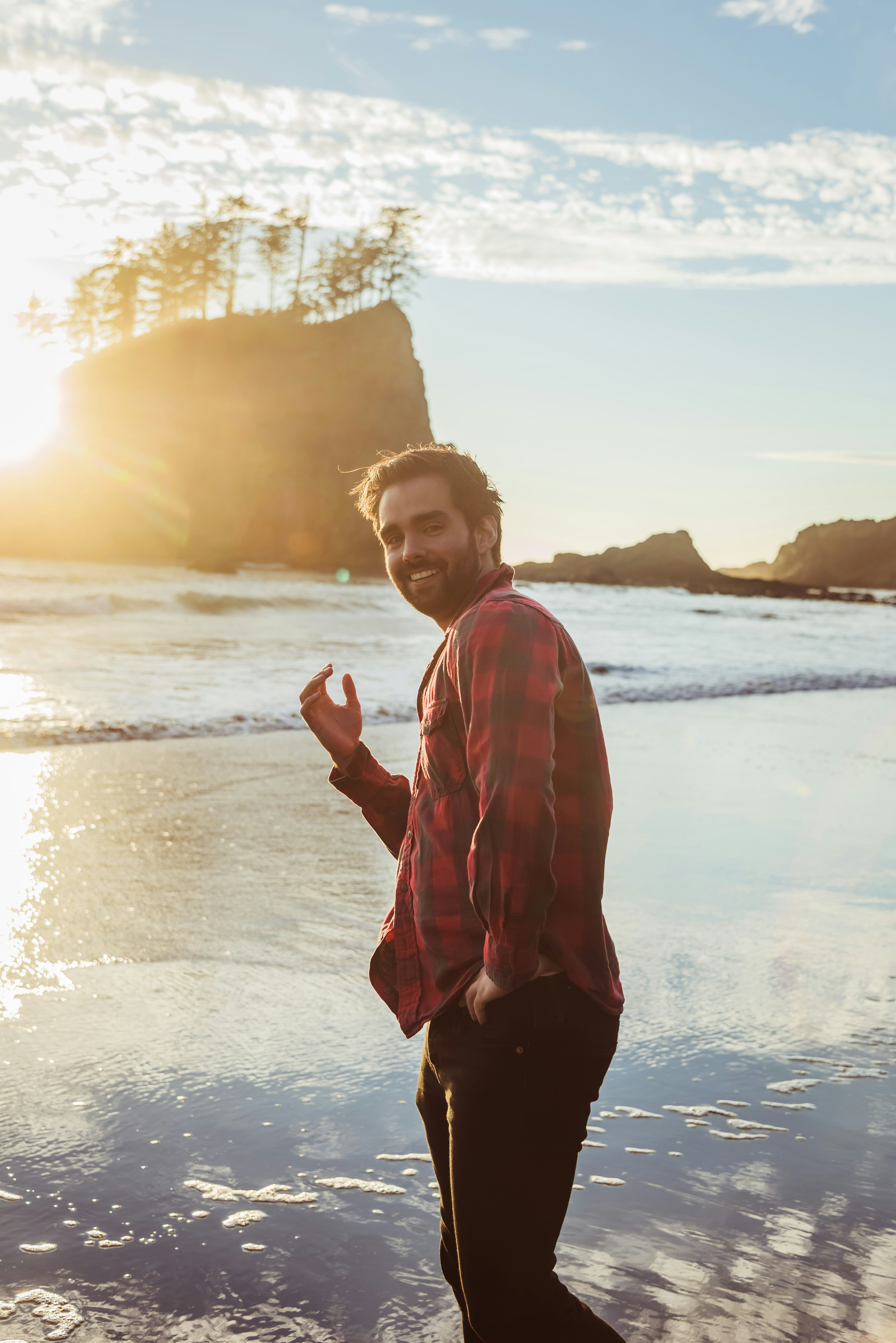 a man standing on a beach next to the ocean