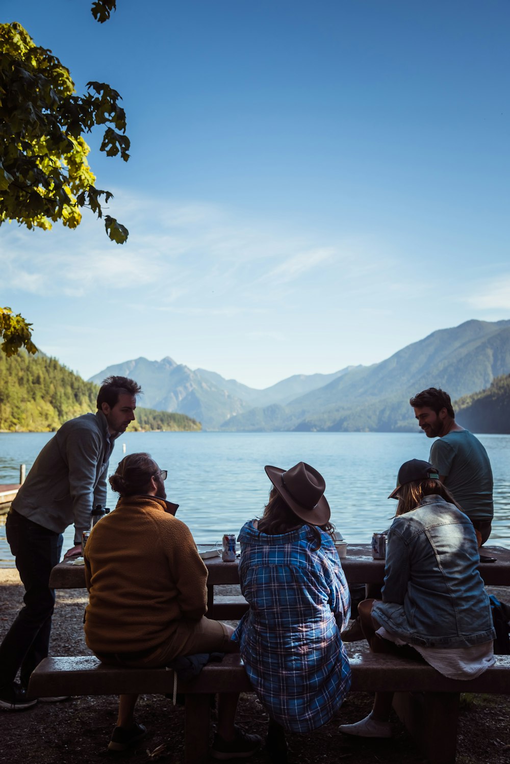 a group of people sitting on top of a wooden bench