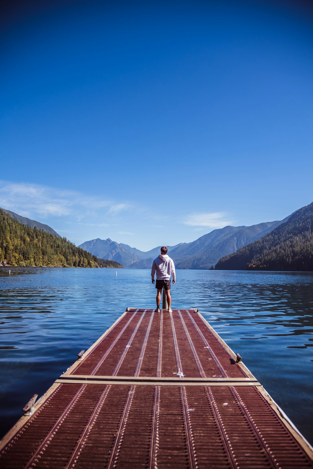 a man standing on a dock on a lake