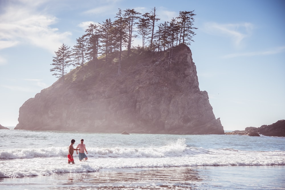 a couple of people that are standing in the water